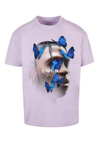 Lys lilla bomulls-t-skjorte med et grafisk motiv av et ansikt omgitt av blå sommerfugl-illustrasjoner og teksten "LE PAPILLON" under.