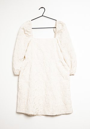 Off-white, knitter Kleid mit quadratischer Ausschnitt, gepufften Ärmeln und elastischen Bündchen, hängt an einem schwarzen Haken vor einem weißen Hintergrund.