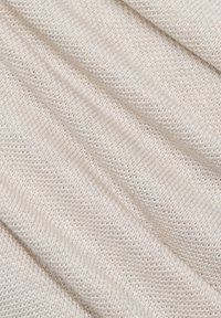 Tissu crème texturé avec un motif de tricot lâche, présentant un tissage doux et uniforme ainsi que de légères variations d'épaisseur.