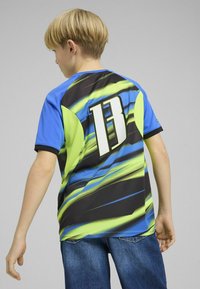 Lühikeste varrukatega sportlik särk, millel on sinised, mustad ja neoonrohelised lainelised mustrid. Seljal on suur number "13". Võrgusilma tekstuur.
