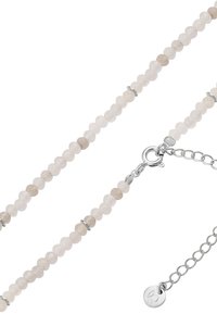 Nakit od perlica s svijetlosivim i krem perlicama uz srebrne akcentne detalje. Uključuje metalnu kopču i prilagodljivu lančanu ekstenziju.