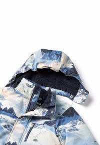 Veste isolée multicolore avec un imprimé photographique de montagne. Elle présente une capuche doublée de fourrure, une fermeture à glissière et des boutons-pression.