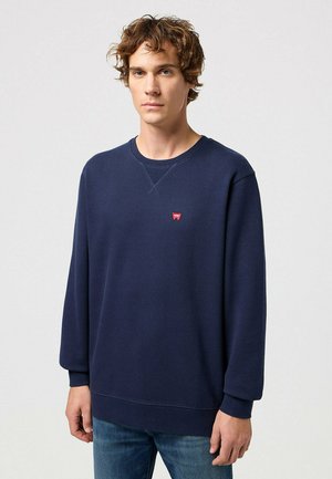 Marineblauwe sweatshirt gemaakt van katoen, met een ronde hals en lange mouwen. Klein rood logo op de borst, ribgebreide boorden en zoom.