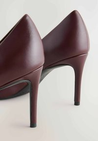 Bordeaux hoge hakken van soepel leer, met een puntige neus en slanke silhouet met een slanke stiletto hak.