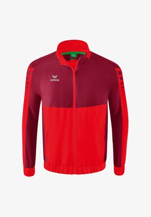 Red and burgundy athletic jacket with a high collar, zip closure, white logo, and contrasting sleeve stripes; smooth, lightweight fabric.