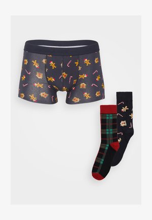 Boxer briefs en azul marino con un estampado de galletas de jengibre y bastones de caramelo; incluye dos pares de calcetines: uno de cuadros rojos y otro negro con diseño de galletas de jengibre.