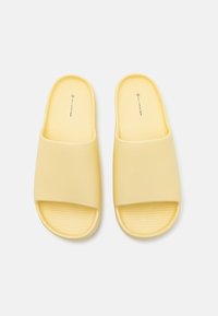 Gule slip-on sandaler laget av mykt materiale; bred rem over toppen og teksturert såle for grep. Glatt finish med subtil merkevare inni.