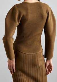 Brun, ribbade stickade tröja med en figurnära design och lång ärm, i kombination med en matchande ribbade kjol som har vertikala ränder.