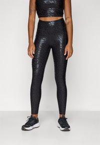 Sorte høye leggings med et glanset leopardmønster, laget av elastisk materiale, kombinert med en matchende cropped topp.