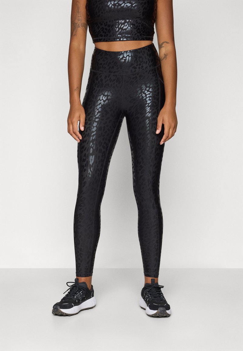 Sorte høye leggings med et glanset leopardmønster, laget av elastisk materiale, kombinert med en matchende cropped topp.