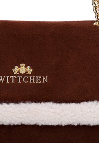 Sac en cuir suédé marron avec une bande texturée blanche, quincaillerie dorée avec le logo "WITTCHEN" et une chaîne en bandoulière. Surface lisse.