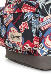 Mochila de tela multicolor con patrones retro de signos y palmeras, con un fondo gris texturizado y parche con el logotipo de Eastpak.