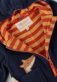 Marineblaue Fleece-Hoodie-Jacke mit einer orangefarbenen Fuchs-Applikation auf der Vorderseite, gestreiftem orangem und gelbem Futter sowie einem Reißverschluss.