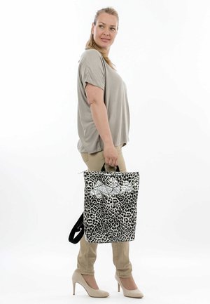 Black and white leopard print tote bag with contrasting geometric silver accents and a top zipper, featured with short black handles.