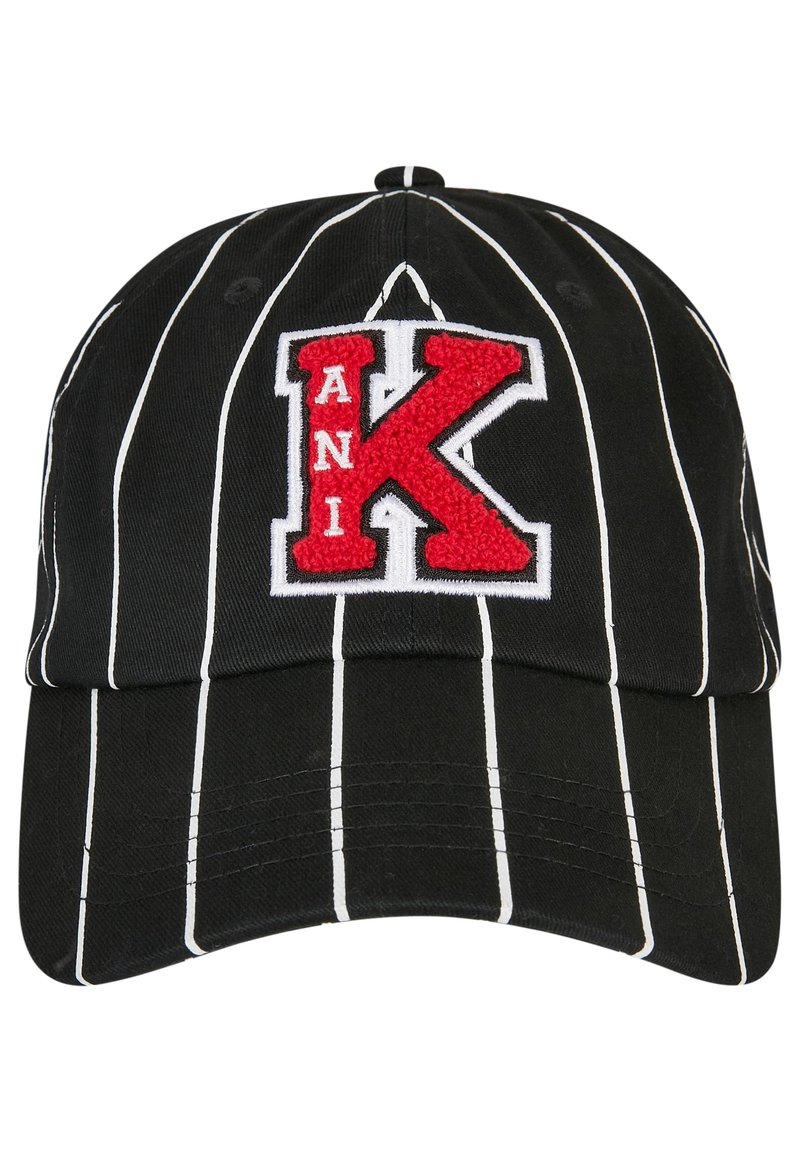 Mustahuppoinen baseball-lippis, jossa on valkoisia pystysuoria raitoja, ja etuosassa punaisella ja valkealla kirjailtu kirjain "K" ja teksti "ANI".