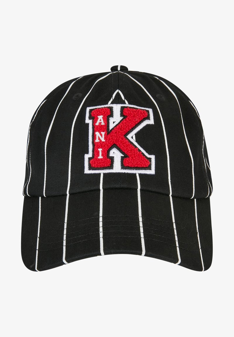 Mustahuppoinen baseball-lippis, jossa on valkoisia pystysuoria raitoja, ja etuosassa punaisella ja valkealla kirjailtu kirjain "K" ja teksti "ANI".