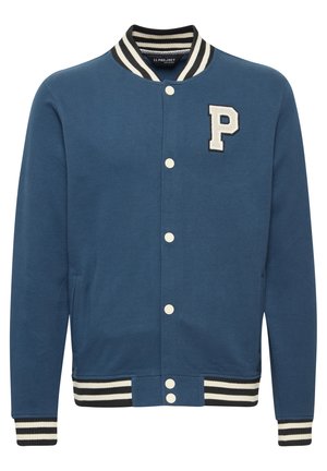 Veste varsity bleue en mélange de coton, présentant un écusson blanc en forme de "P", un col et des poignets rayés côtelés, et une fermeture à boutons-pression.