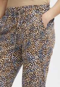 Lässige, gemusterte Hose mit elastischem Bund und Kordelzug. Sie hat eine Mischung aus braunen, schwarzen und hellblauen Punkten.