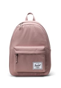 Rosa tygryggsäck med en böjd form, framfick för blixtlås och en vit varumärkesetikett. Har dubbla övre blixtlås och justerbara axelremmar.
