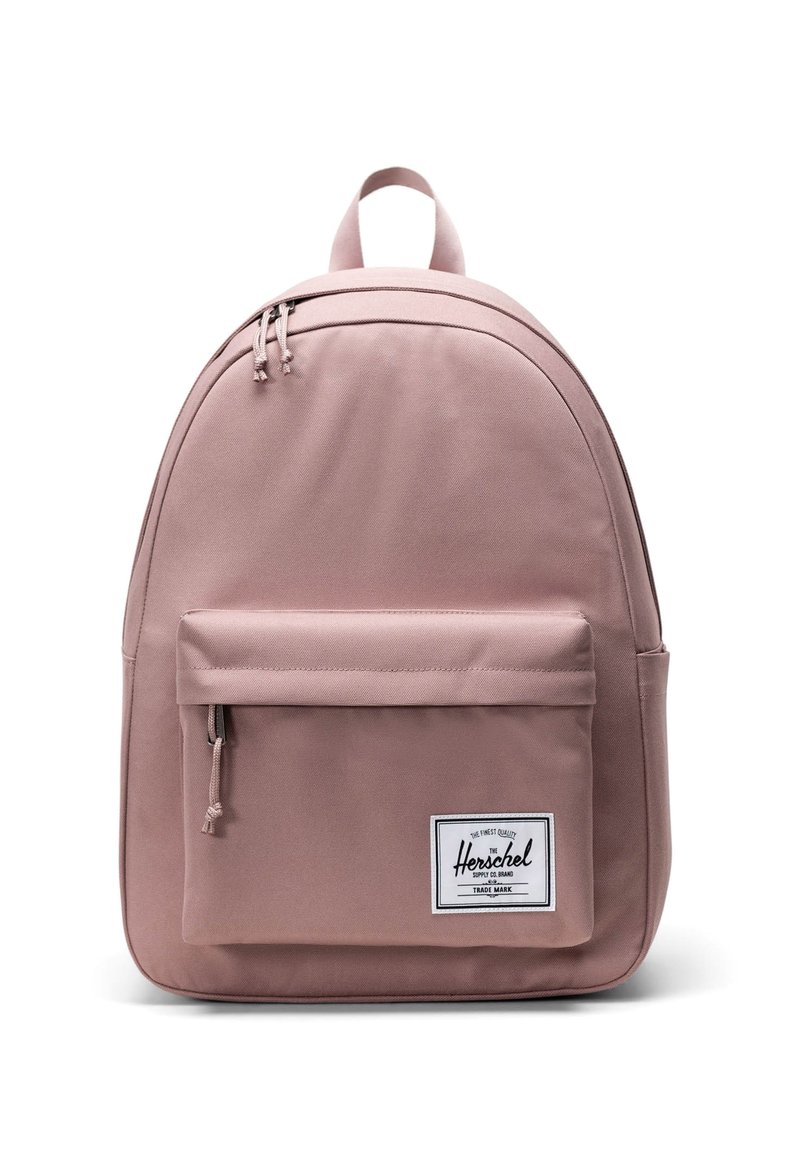 Rosa tygryggsäck med en böjd form, framfick för blixtlås och en vit varumärkesetikett. Har dubbla övre blixtlås och justerbara axelremmar.