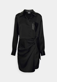 Robe portefeuille noire en tissu lisse avec une poche en cuir, des manches longues et un détail torsadé à la taille. Dotée d'un col à revers.