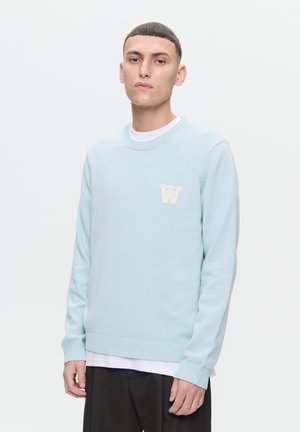 Maglione azzurro chiaro in tessuto morbido, con collo a girocollo e polsini a coste, impreziosito da un logo "W" crema a contrasto sul petto.