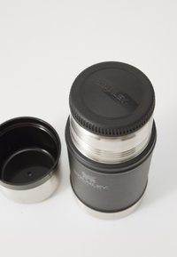 Stainless steel vacuum flask with a black matte finish, featuring a textured black lid and a detachable inner cup. Logo visible.