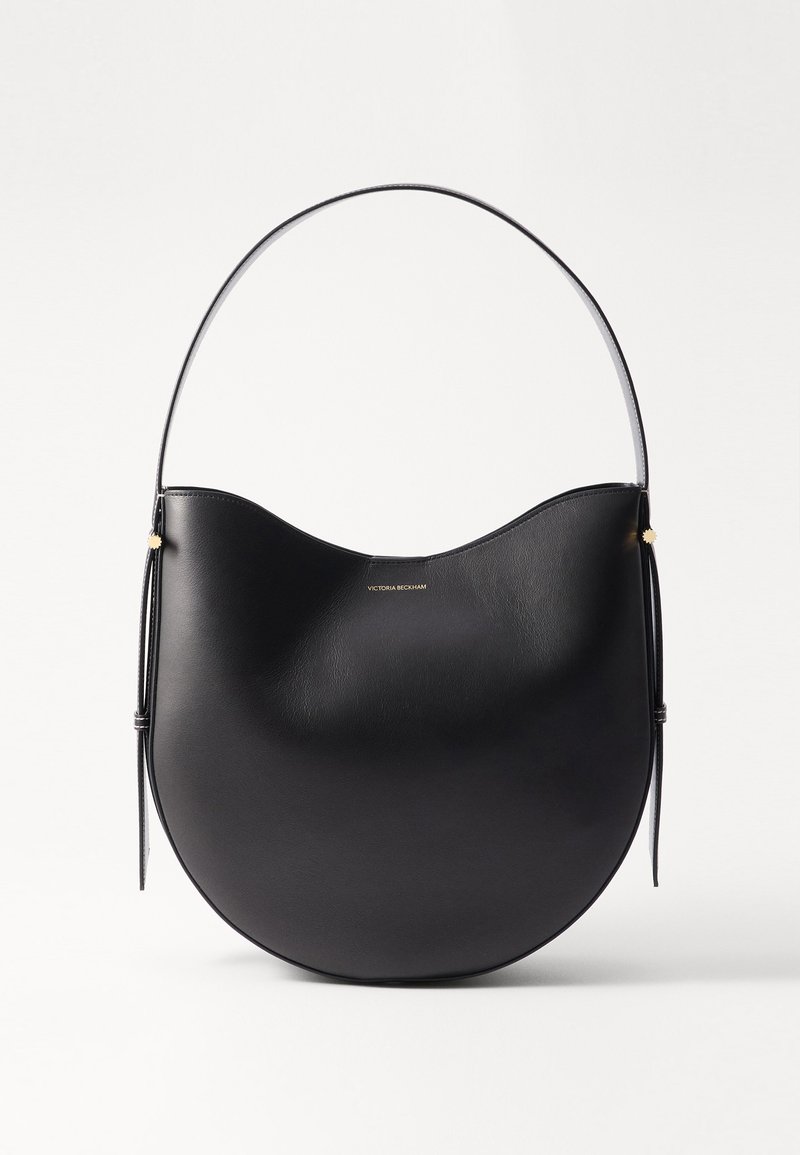 Geantă de umăr din piele neagră, cu o formă curbată, mână subțire și accente aurii subtile. Textură netedă cu un design minimalist.