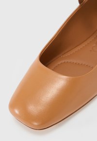 Beżowe, sztuczne skórzane płaskie buty z kwadratowym noskiem i minimalistycznym wzornictwem. Gładka tekstura z delikatnym przeszyciem na wkładce.