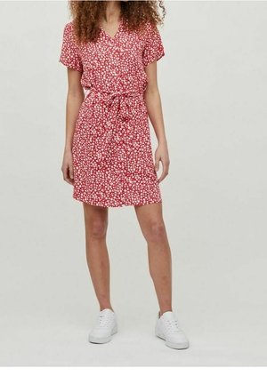 Robe florale rouge avec un décolleté en V, des manches courtes et une taille à cordon. Fabriquée en tissu léger, elle présente un motif de fleurs éparses.