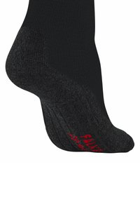 Calzino nero con un design testurizzato e a coste. Presenta accenti neri imbottiti e un logo rosso sulla suola. Tessuto morbido e traspirante.