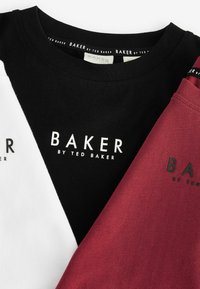 Tris marškiniai: vieni juodi, vieni balti, vieni bordo. Visi iš medvilnės, su užrašu "BAKER by TED BAKER" švariu, ryškiu šriftu.