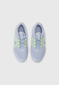Baskets de sport bleu clair avec des accents verts, en tissu mesh, à bout arrondi et avec des lacets plats. Présence du logo sur les côtés et la languette.