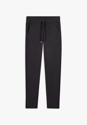 Pantalon de survêtement noir en tissu doux, doté d'une taille à cordon, de poches latérales et de jambes étroites effilées.