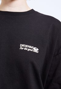 Black cotton T-shirt featuring a crew neckline and a small white logo with the text "DRDENIM For the good times" on the chest.