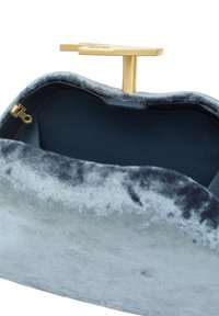 Bolso de mano azul de terciopelo con una textura suave y curva, y un cierre de metal dorado. El interior es de tela azul marino con un pequeño bolsillo con cremallera.