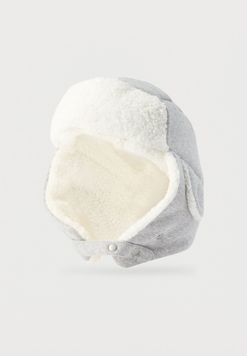 Chapeau de trappeur d'hiver gris avec doublure en polaire blanche et protège-oreilles, doté d'une fermeture à bouton-pression sous le menton.