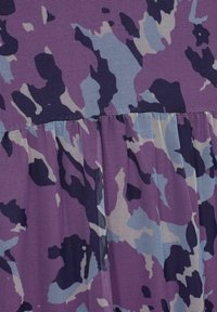 Tessuto a rete viola e blu con un motivo camouflage, caratterizzato da un dettaglio di piega arricciata all'orlo.