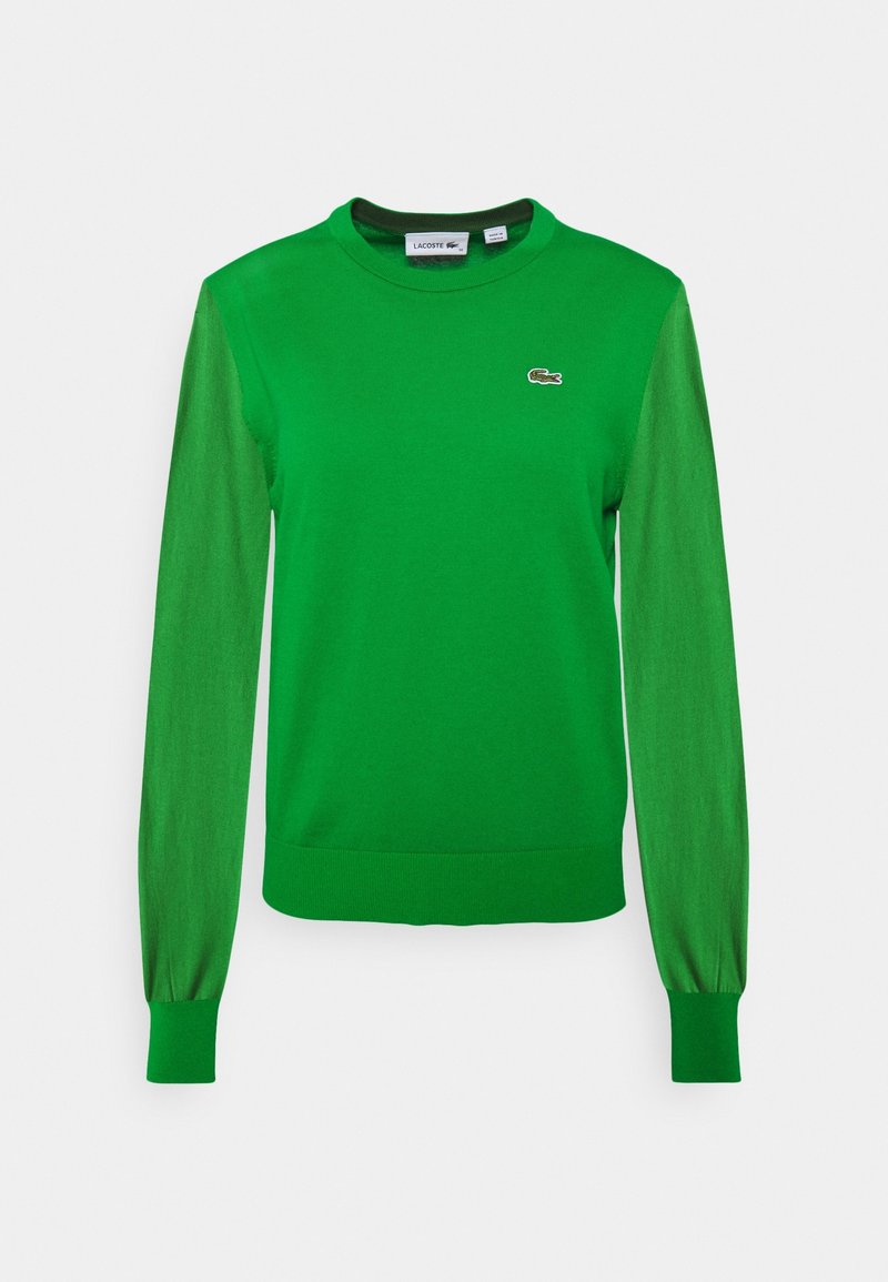 Zielony sweter z pulowerem z długimi rękawami. Posiada okrągły dekolt i prążkowane mankiety. Na piersi znajduje się logo Lacoste w kontrastującym kolorze.