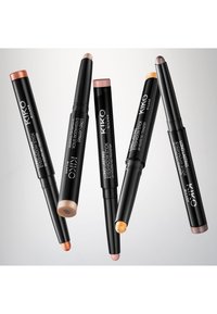 Seis barras de sombra de ojos KIKO Milano, con acabados metálicos y mate en tonos bronce, beige, melocotón, dorado y violeta. Envases cilíndricos negros.