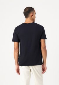 Navy blue cotton t-shirt with short sleeves and a crew neckline, featuring a simple design and a relaxed fit. No visible patterns or accents.