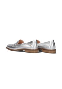 Zilveren metallic loafers met een gestructureerde afwerking, voorzien van een bruine houten hak en een kleine decoratieve accent aan de zijkant.