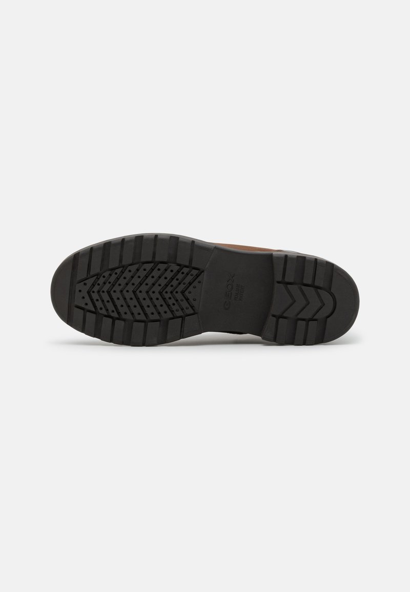 Sneakerzool in zwart rubber, met een loopvlakpatroon van groeven en verhogingen voor grip. Verstevigde hiel voor duurzaamheid.