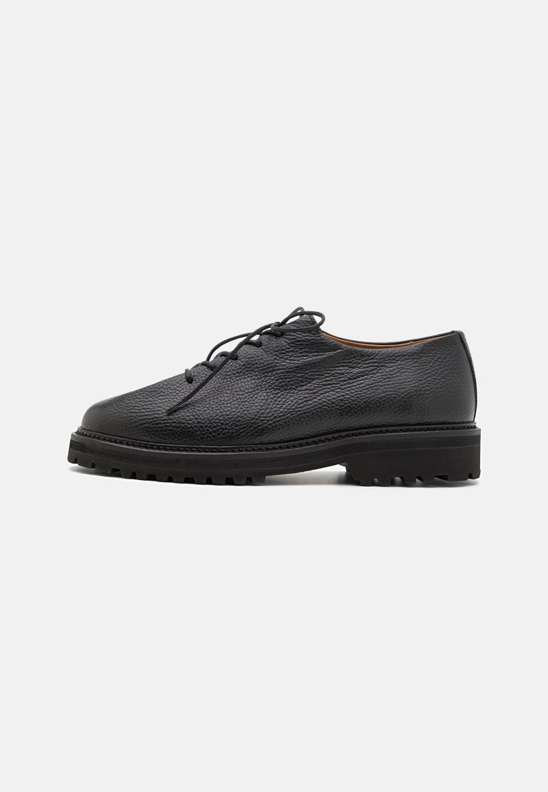 Black leather shoes featuring a textured finish, round toe, lace-up design, and rugged sole with pronounced tread pattern.