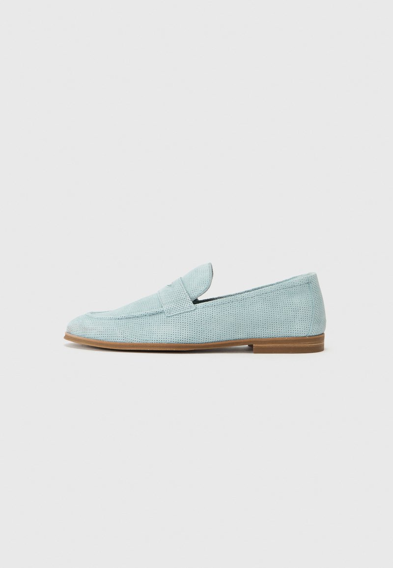 Mocasines de color azul claro hechos de material perforado con suela plana, que presentan una tira decorativa a través del empeine y detalles de costura mínimos.