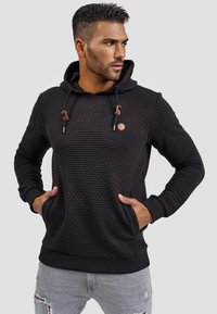 Zwarte hoodie met een gewafeld patroon, koordsluiting, kangoeroezakken en geribde manchetten. Leren patch op de borst.