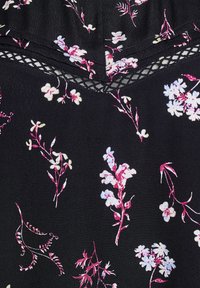 Tessuto nero con una stampa floreale di fiori blu e rosa. Un dettaglio in pizzo sul collo aggiunge texture. Materiale morbido e leggero.