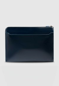 Funda para portátil de cuero azul marino con textura suave, que cuenta con cierre de cremallera superior y un bolsillo frontal con un sutil contorno azul.