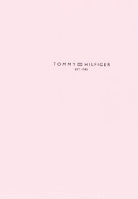 Ljust rosa tyg med "TOMMY HILFIGER"-logotypen i mörkgrått. Slät textur med en enkel och ren design.