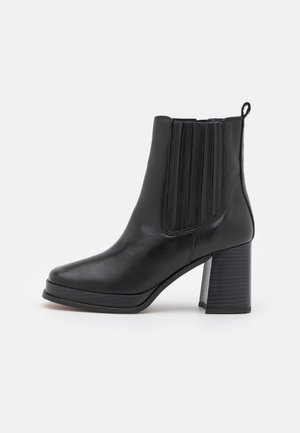 Schwarzer Leder-Stiefelette mit Blockabsatz, elastischen Seitenpaneelen und Zuglasche hinten, im rechten Seitenprofil auf weißem Hintergrund dargestellt.